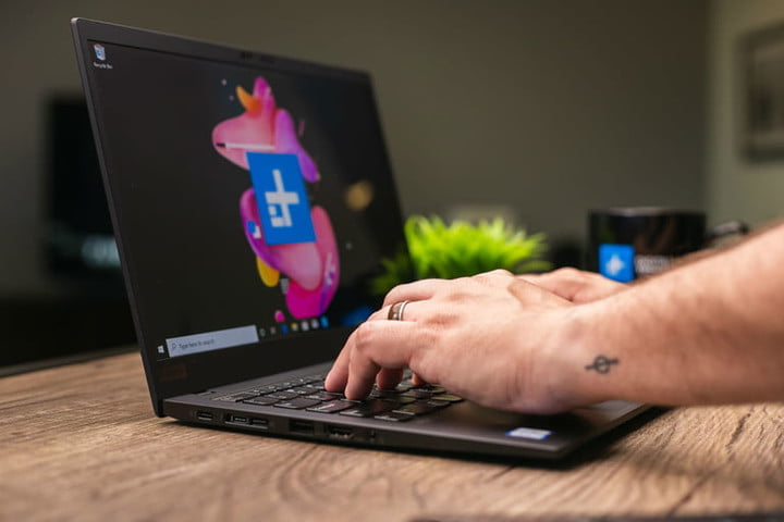 Person typing on Lenovo laptop.